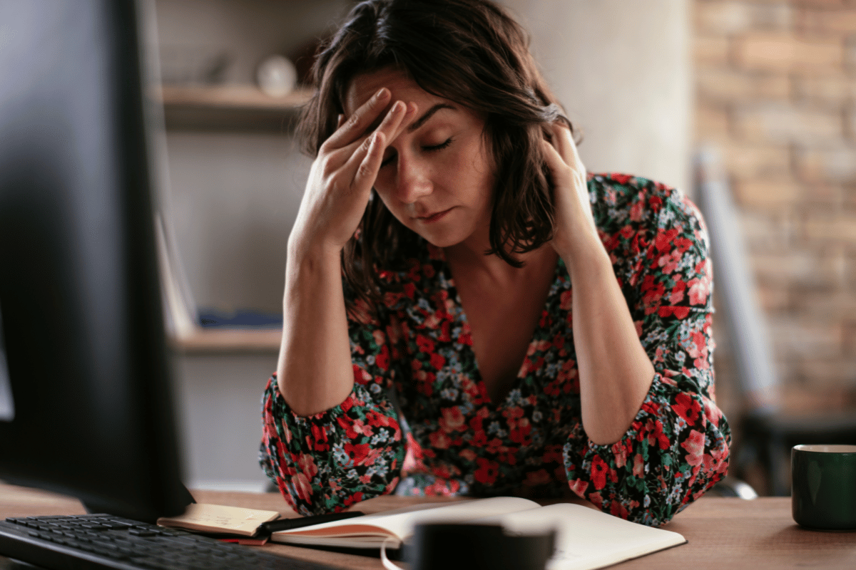 a woman resting her head on her hand and looking uncomfortable