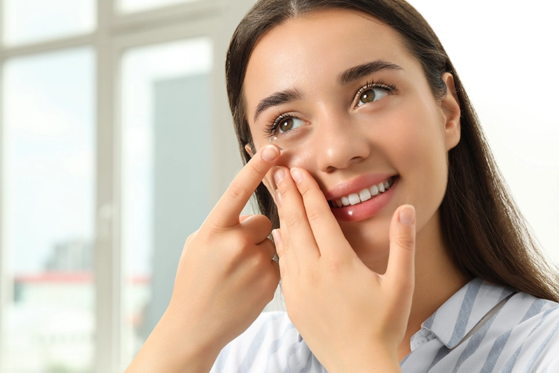 contact-lenses a smiling woman putting in a contact lens
